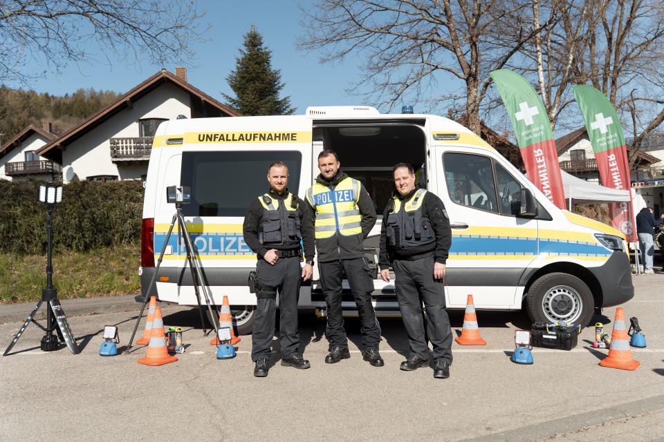 Polizistinnen und Polizisten der Unfallaufnahme vor einem Polizeifahrzeug