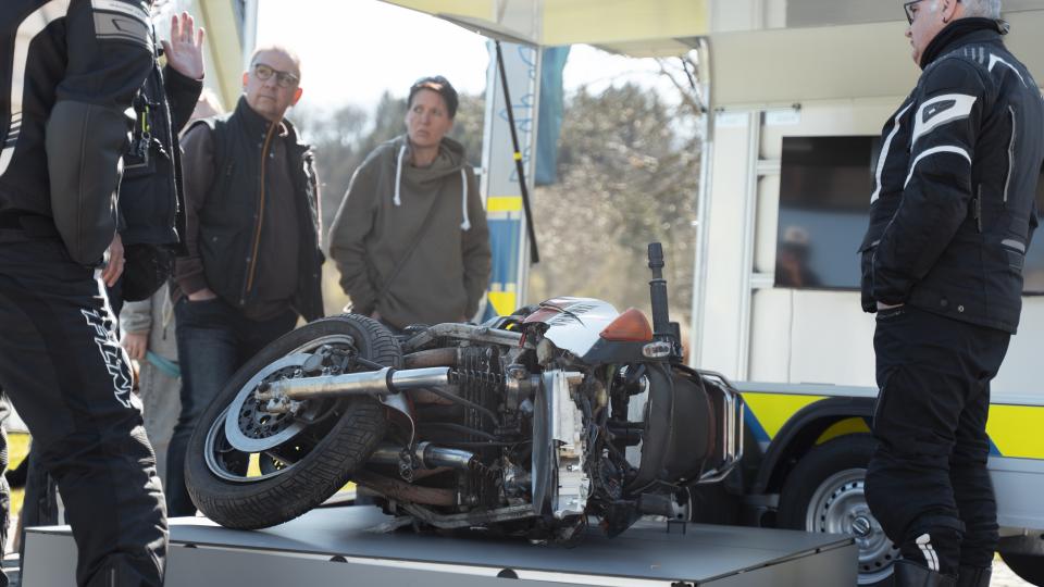 Ein Unfallmotorrad als Schauobjekt mit Zuschauern