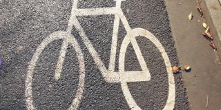 Auf einer Straße ist mit Farbe ein weißes Fahrrad markiert