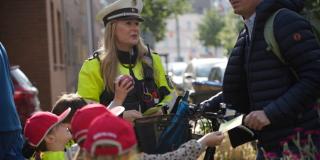 Kinder verteilen Dank- und Denkzettel an Verkehrsteilnehmende zusammen mit der Polizei